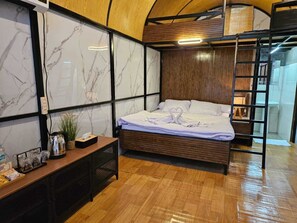 Une chambre à coucher moderne avec un lit, une table de chevet et une tête de lit en bois.