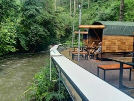 Un paseo junto al río con una estructura de madera y bancos.