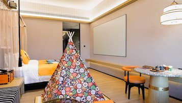 Une chambre d’hôtel avec un lit, une petite table et des chaises, un mur décoratif et une grande fenêtre.