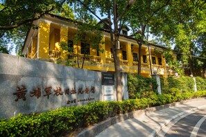 Edifício amarelo com base de pedra e letreiros em caracteres chineses.