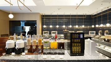 A modern cafe with a self-serve beverage station, a pizza display, and a seating area with wooden benches.