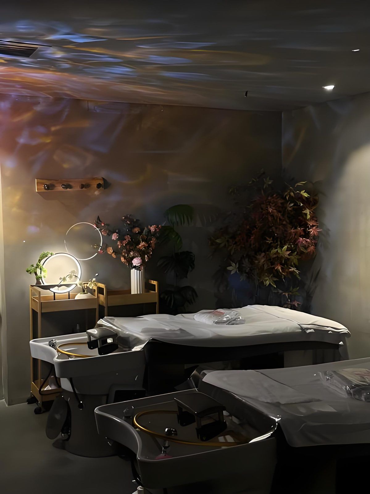 Una habitación moderna con cama, mesita de noche y un espejo montado en la pared.