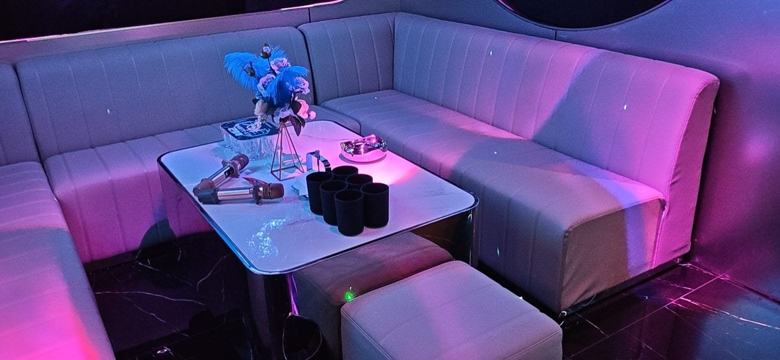 Un área de estar moderna con un sofá, una mesita y un arreglo floral decorativo.