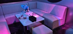 A modern lounge area with a sofa, a small table, and a decorative flower arrangement.