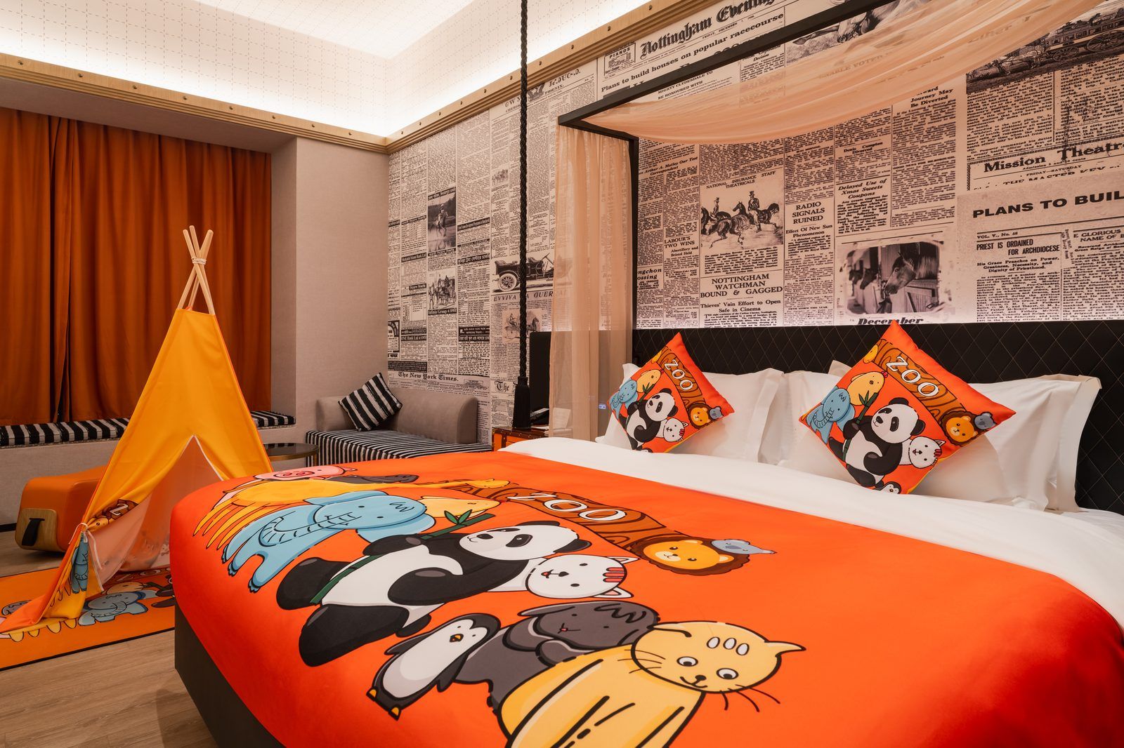 A hotel room with a large bed, a tent, and a wall covered with newspaper clippings.