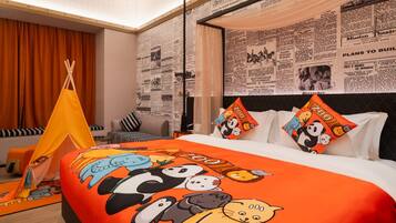 A hotel room with a large bed, a tent, and a wall covered with newspaper clippings.