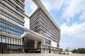 Een modern hotel met een opvallende, gebogen ingang en meerdere verdiepingen.