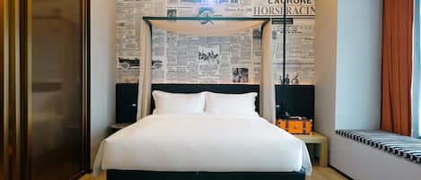 Una habitación de hotel con una cama grande, un cabecero con dosel, una pared con recortes de periódicos, una mesita de noche y una maleta.