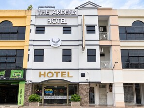Un hôtel avec une enseigne bien visible portant l’inscription « THE ARDENS HOTEL » et un logo au-dessus de l’entrée.