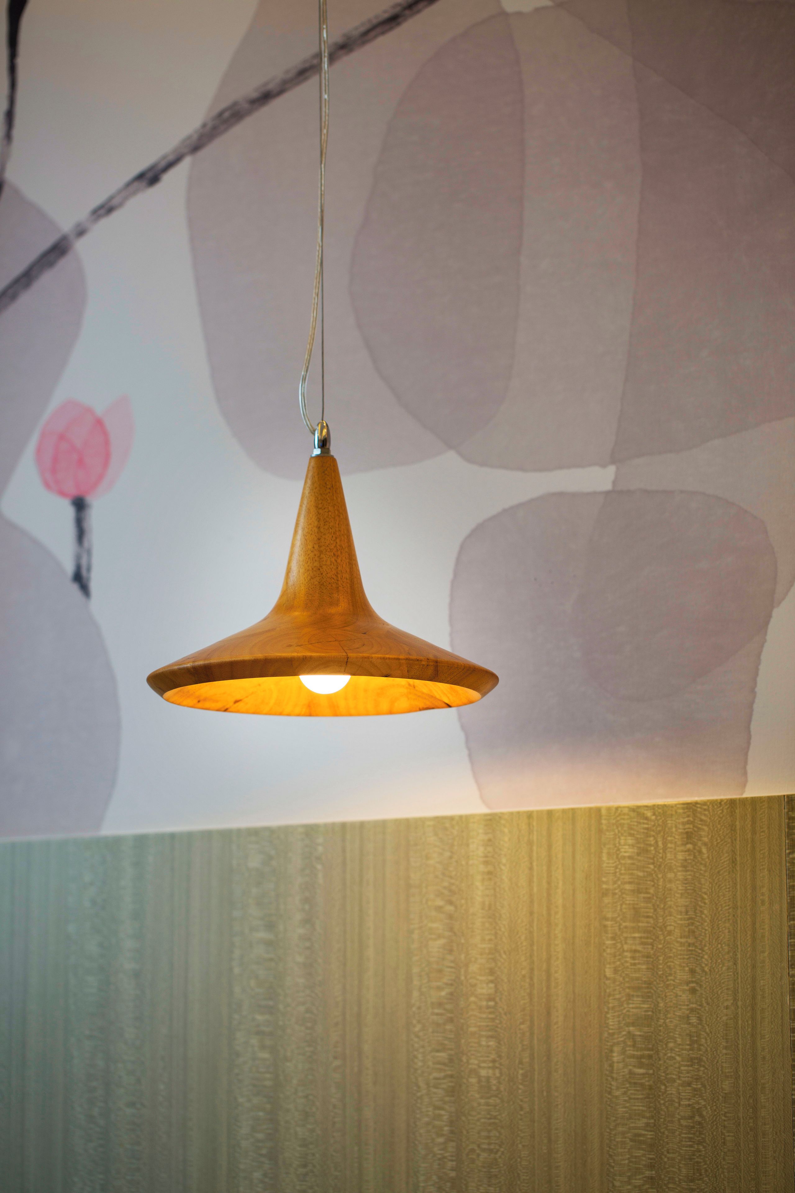 A pendant light fixture with a wooden shade hanging from a ceiling.