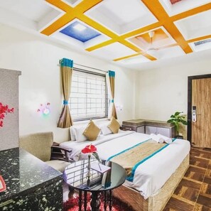 Habitación de hotel con cama, escritorio, silla, ventana con cortinas y tragaluz en el techo.