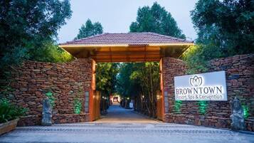 A stone archway leading to a covered entrance with a sign for BrownTown Resort, Spa & Convention.