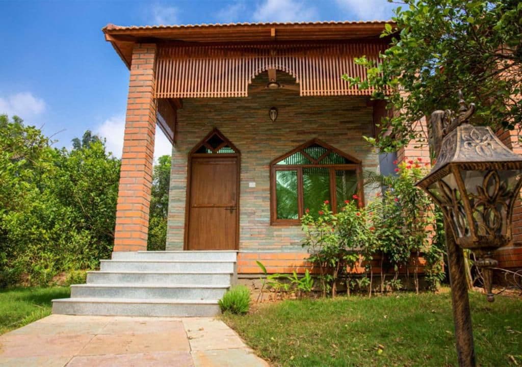 A two-story house with a brick facade, a wooden door, and a window with a wooden frame.