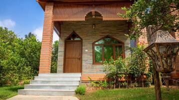 A two-story house with a brick facade, a wooden door, and a window with a wooden frame.