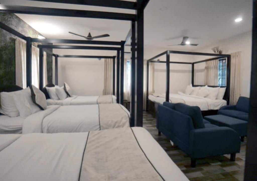 Ein Hotelzimmer mit einem Himmelbett, einer Sitzecke und einem Deckenventilator.