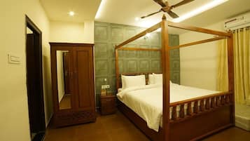 Ein Hotelzimmer mit einem Himmelsbett, Deckenventilator, Kleiderschrank und Spiegel.