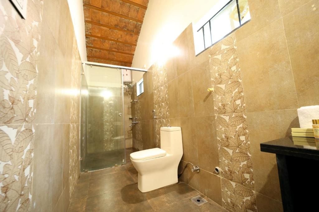 A bathroom with a toilet, shower, and a sink.
