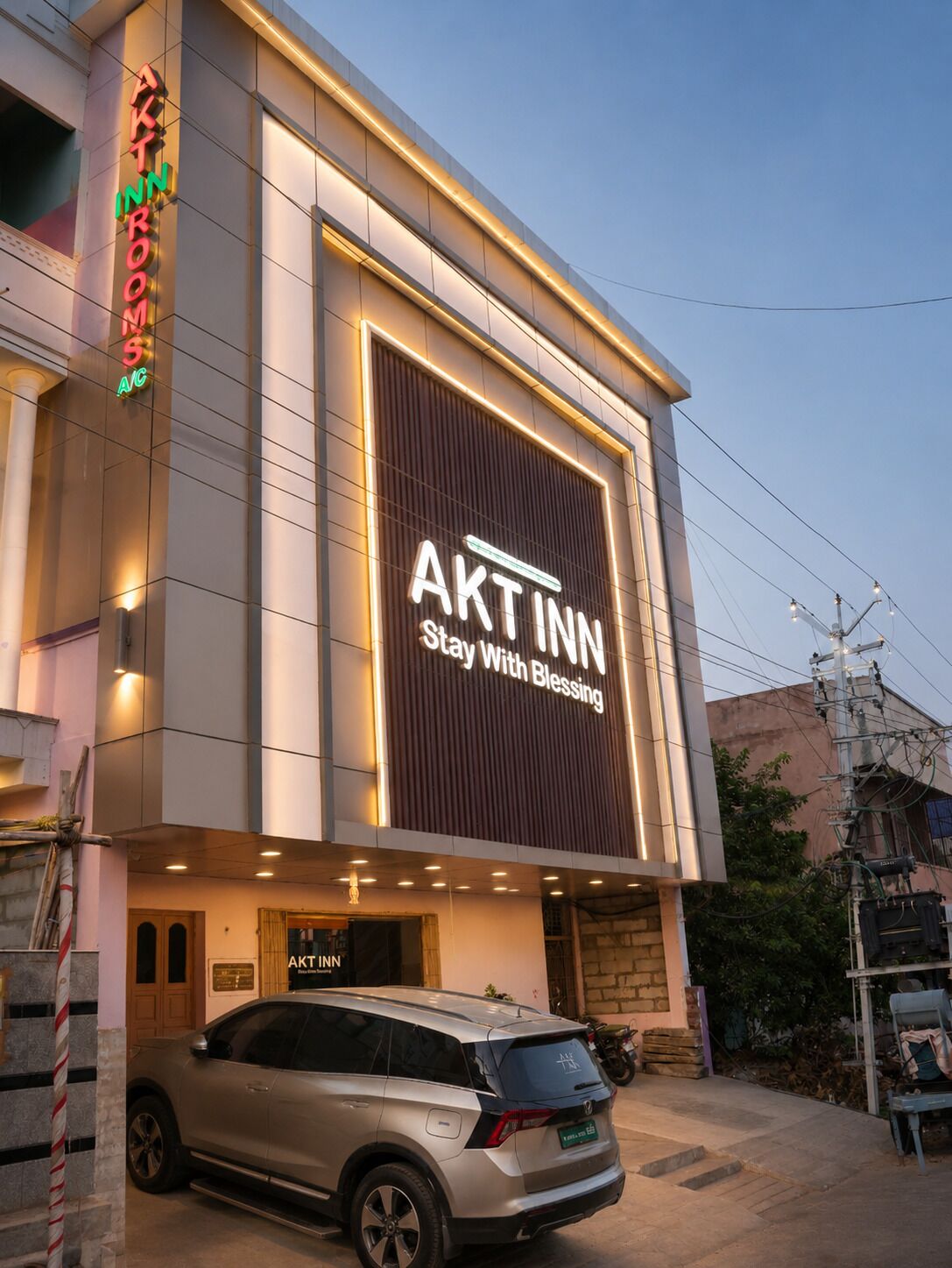 A building with a large illuminated sign reading 'AKT INN Stay With Blessing.'