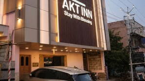 Un edificio con un letrero iluminado grande que dice 'AKT INN Stay With Blessing'.