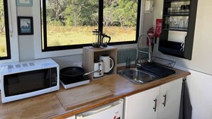 A compact kitchen with a microwave, toaster, and sink. - Hamilton Country Retreat 1 by Tiny Away (Kangaroo Valley)