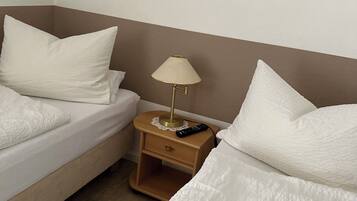 Ein Hotelzimmer mit zwei Betten, einem Nachttisch mit Lampe und einem Bild an der Wand.