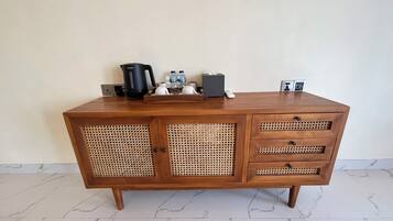 Un meuble en bois contenant une machine à café, des bouteilles et une boîte de mouchoirs.