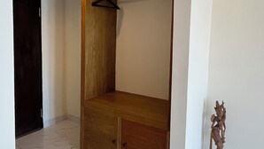 Una habitación con un banco de madera, un perchero y una estatua.