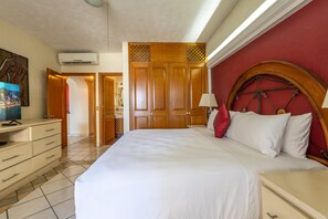 Une chambre d’hôtel équipée d’un lit, d’un bureau, d’une télévision et d’une armoire.