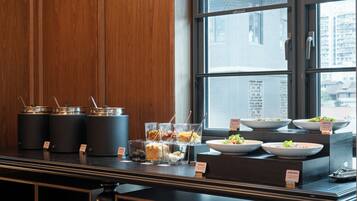 A buffet setup with various dishes and condiments.