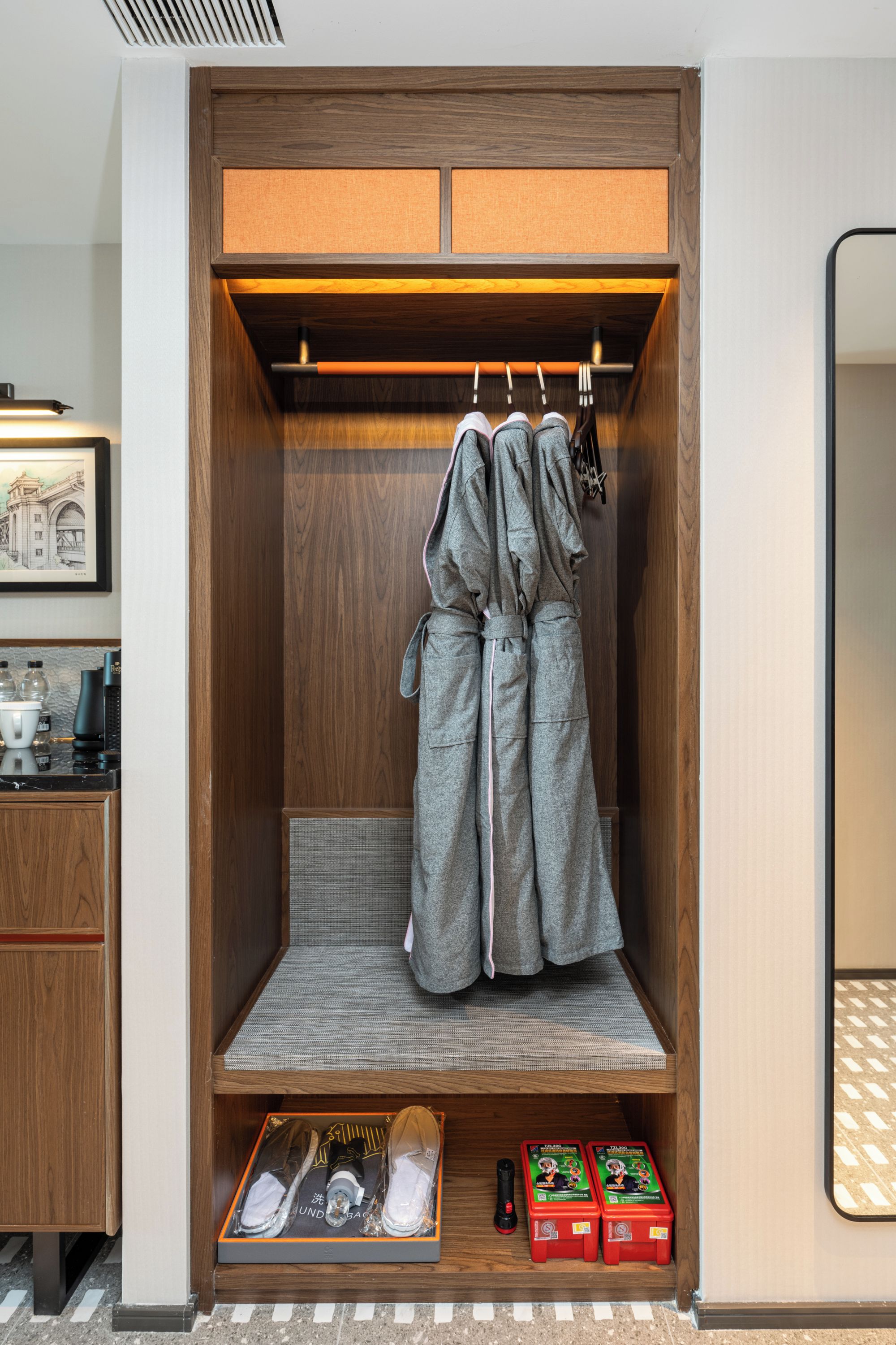 Ein begehbarer Kleiderschrank mit Holzausstattung, einer Kleiderstange und einem Regal mit Gegenständen.