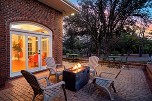 A patio with outdoor seating and a fire feature. - ACL Weekend | Sleeps 22 | Pool + Hot Tub + Sauna | Game Room | The Reset Estate (Austin)
