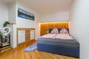 Ein Schlafzimmer mit einem Bett, Nachttischen, einem Wandregal und einem Gemälde.