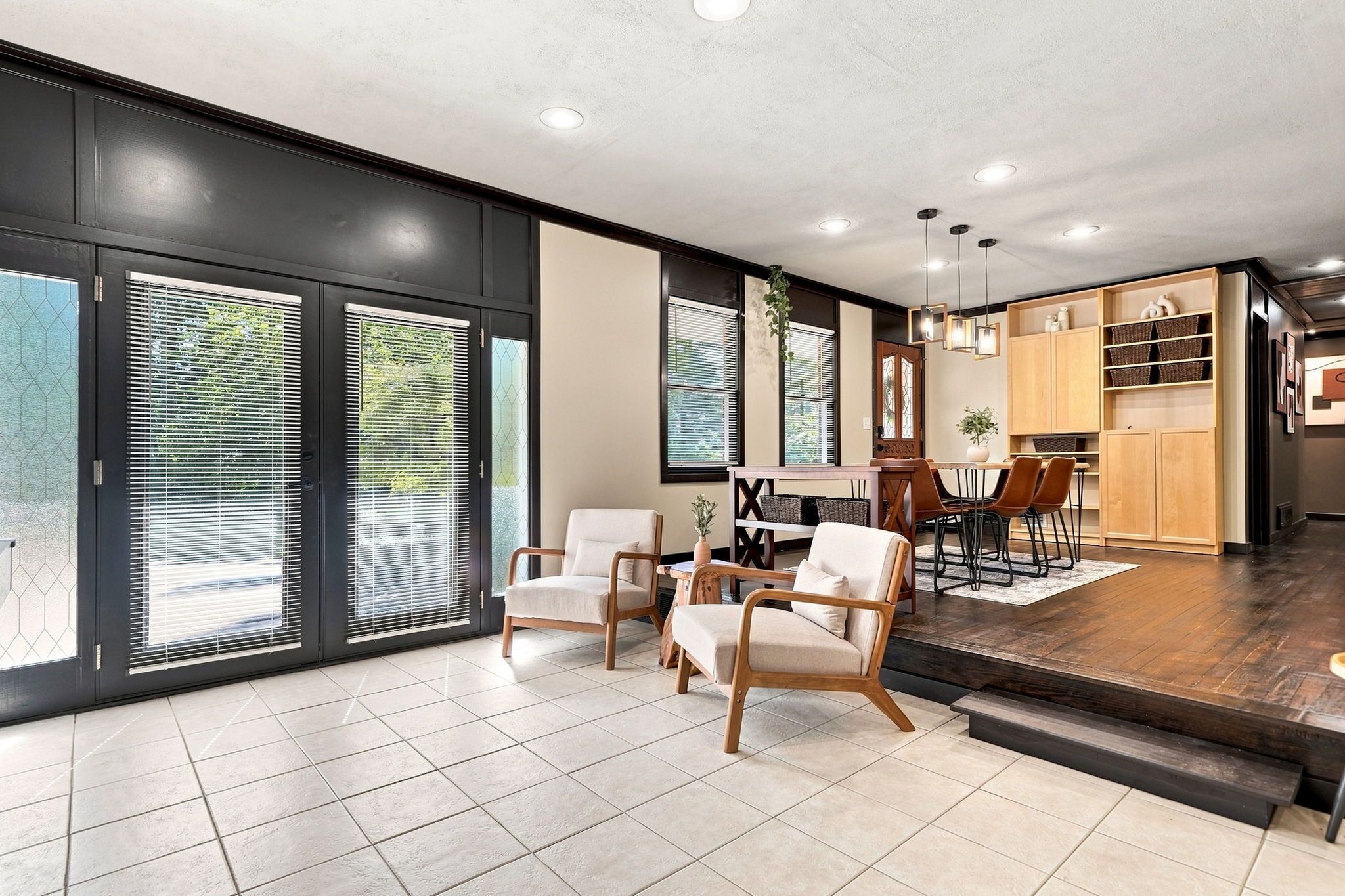 A modern interior with a dining area, kitchen, and large sliding glass doors.