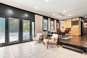 Ein modernes Interieur mit Essbereich, Küche und großen Schiebeglasfenstern.