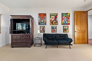 A living room with a TV stand, a sofa, and a door. - Private Pool + Spa | Templeton El Pomar District | Krisyn Vineyards (Templeton)