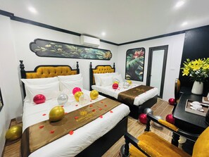 A hotel room with two beds, a desk, and a chair. There are balloons and a bouquet of flowers on the beds. - King Luxury Hotel (Tu Liem)