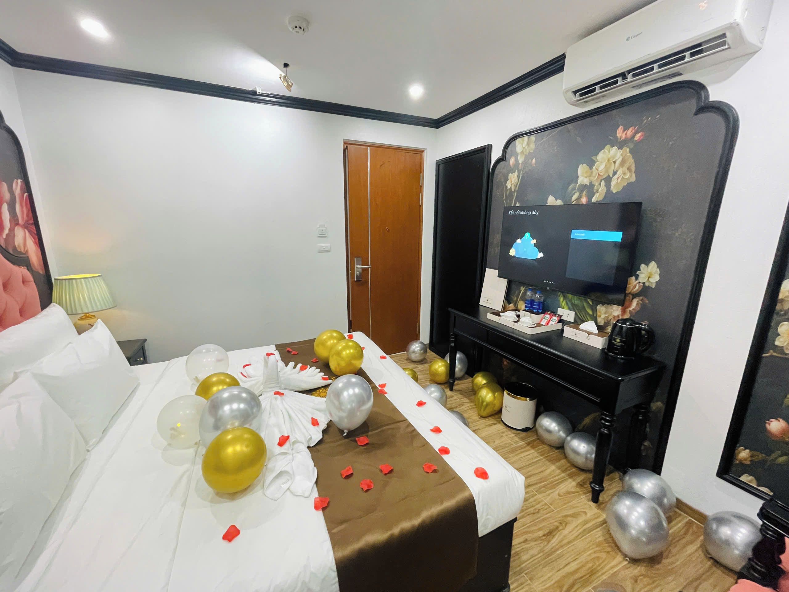 Ein Hotelzimmer mit einem Bett, einem Fernseher, einer Tür und einer Wand mit einem floralen Muster.