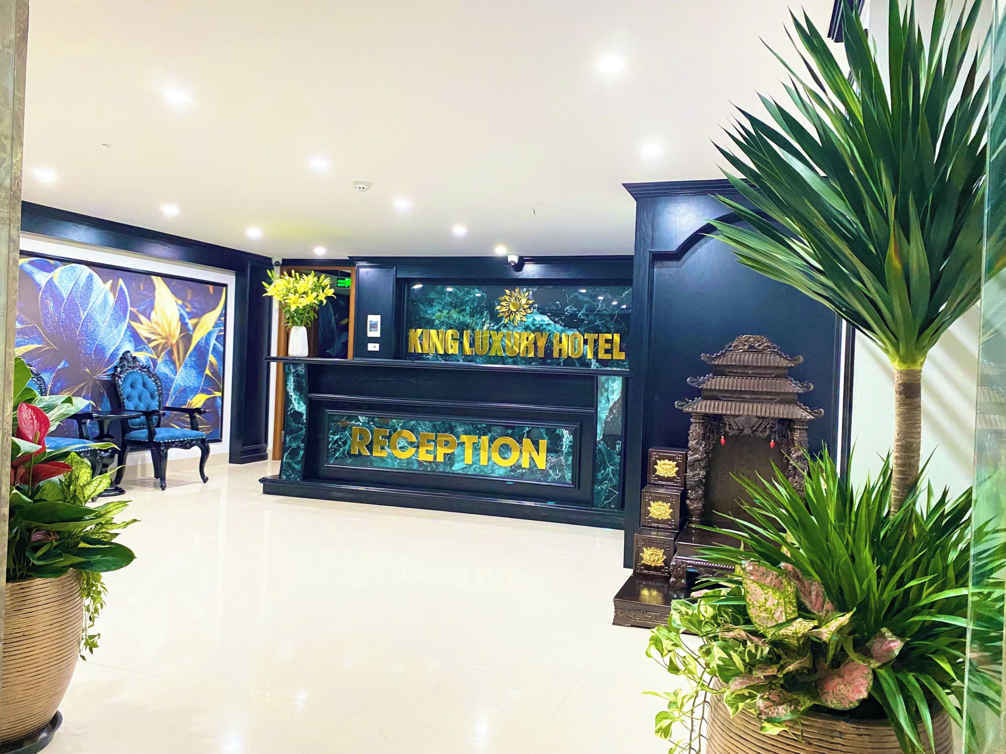 Un área de recepción con mostrador de mármol, un gran mural floral y decoración tradicional.