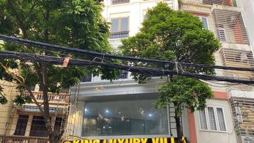 A building with a sign for 'KING LUXURY VILL' and a 'Hair Station' across the street.