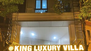 Entrada de hotel con un cartel que dice 'KING LUXURY VILLA' y una escalera que conduce a la entrada.