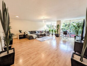 A spacious living room with a sofa set, coffee table, and potted plants. - Big, Bright & Central Polanco 5BR, Sleeps 17! (Mexico City)