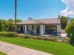 A two-story house with a patio, a swimming pool, and a well-maintained lawn. - Pool + Hot Tub + Game Room + Casita | Golf Course Frontage | The Back Nine (La Quinta)