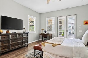 A bedroom with a bed, dresser, desk, and a television. - Pool + Hot Tub + Game Room + Casita | Golf Course Frontage | The Back Nine (La Quinta)