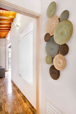 A hallway with a wooden ceiling, a whiteboard, and a wall-mounted decorative plate arrangement. - 2 Bedroom Apartment One Hot tub balcony (Medellin)