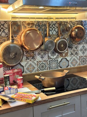 A kitchen with a stove, pots, pans, and various kitchen items on the counter. - 4-bedroom Spanish Hacienda 10 mins MRT Huaykwang/JODD Fair/RCA (Krung Thep Maha Nakhon)