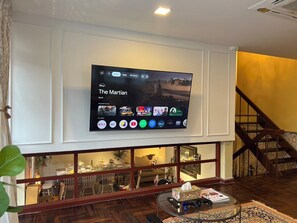 A flat-screen TV mounted on a wall displaying a streaming service interface with 'The Martian' highlighted. - 4-bedroom Spanish Hacienda 10 mins MRT Huaykwang/JODD Fair/RCA (Krung Thep Maha Nakhon)