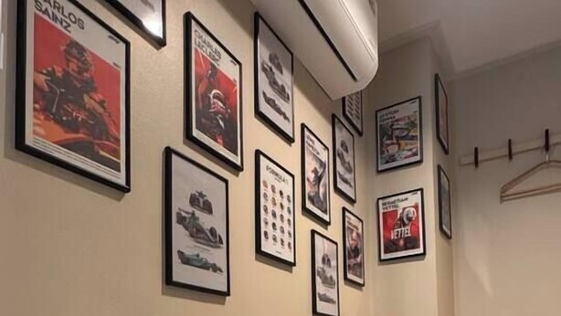 Um corredor com quadros nas paredes, piso xadrez e um radiador.