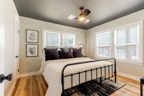 A bedroom with a bed, a ceiling fan, and two windows with blinds. - Walk to UAFS & Dining! Entire Home w/ Deck (Fort Smith)
