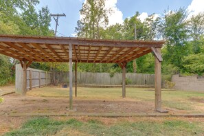 A wooden pergola structure in a backyard with a wooden fence in the background. - Walk to UAFS & Dining! Entire Home w/ Deck (Fort Smith)