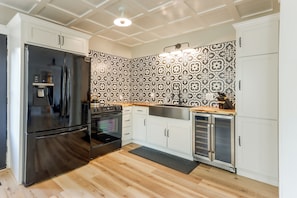 A modern kitchen with a stainless steel refrigerator, oven, and sink. - Walk to UAFS & Dining! Entire Home w/ Deck (Fort Smith)